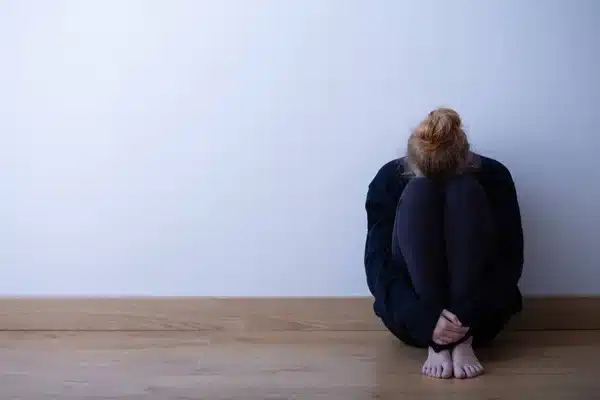 Menina adolescente triste sentado enrolado no chão. Luto por suicídio
